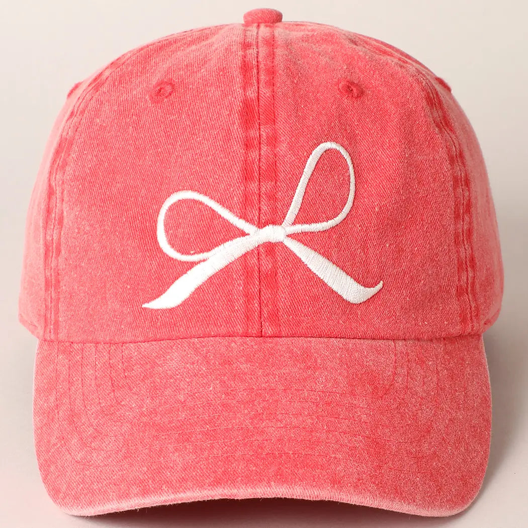 vintage red baseball hat cap with a white bow design on a beige background