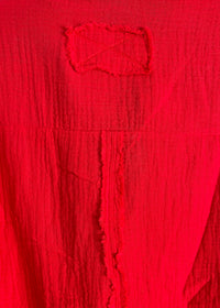 Close-up of a textured red fabric with a logo.