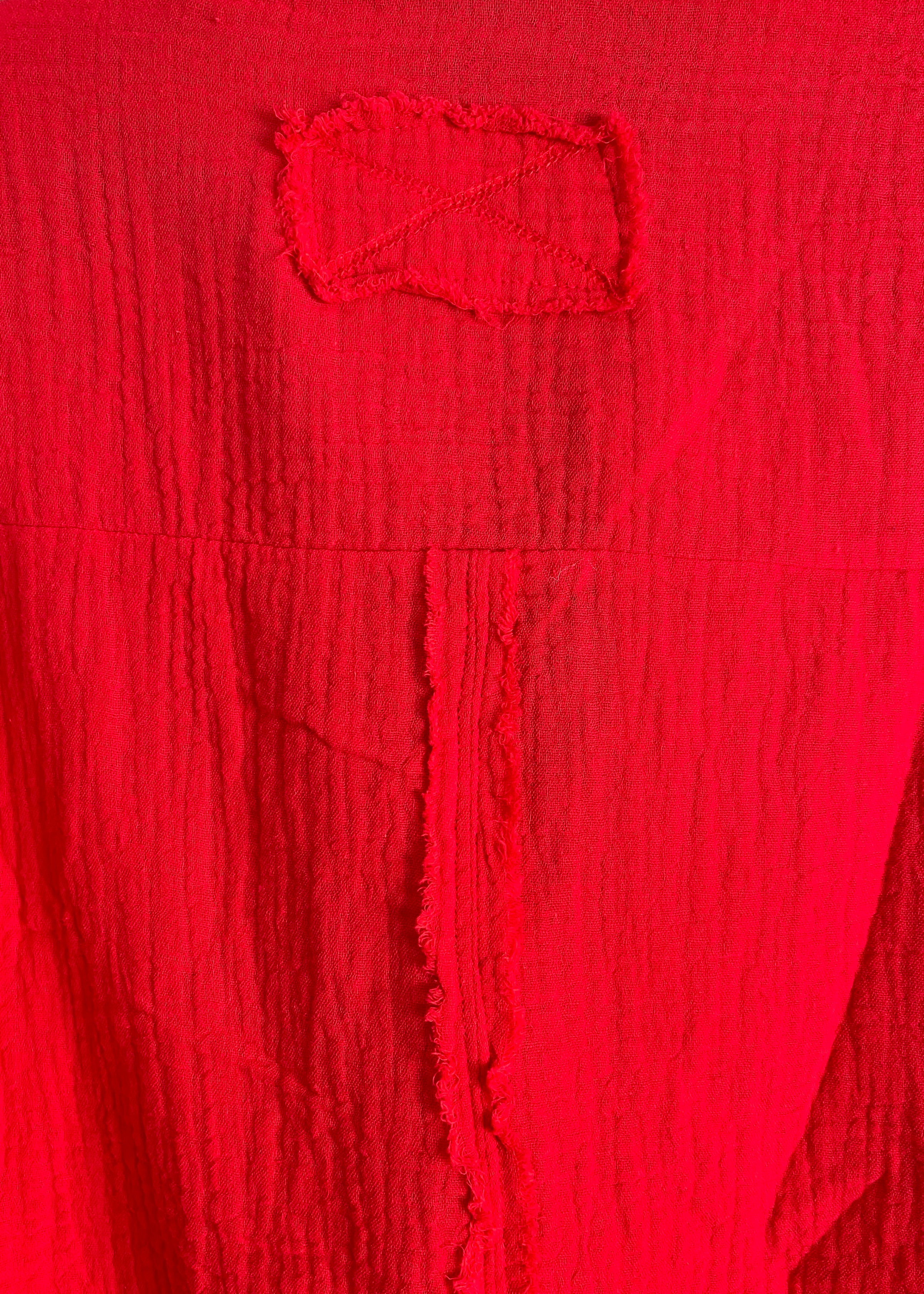 Close-up of a textured red fabric with a logo.